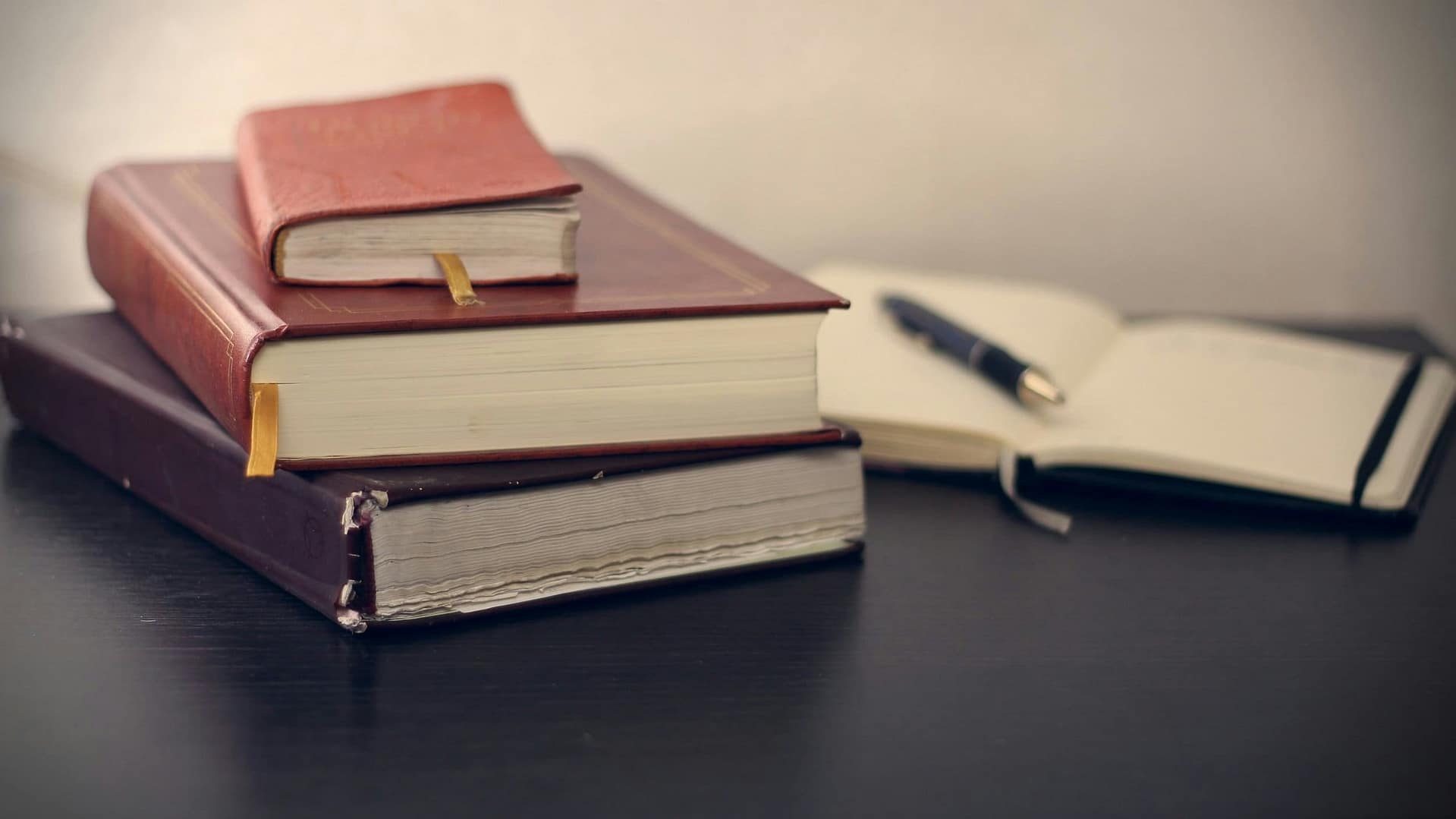 How Do You Know If Probate is Required? 3 A stack of leather-bound books beside an open notebook and pen