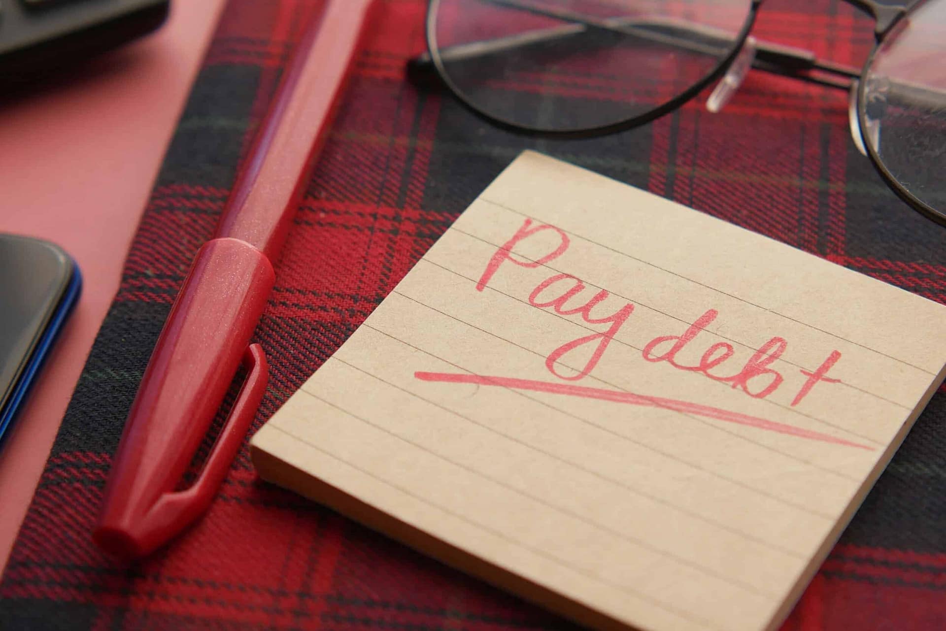 What happens to a debt when someone who is owed money dies? 3 A note reading Pay debt on a notepad beside a pen