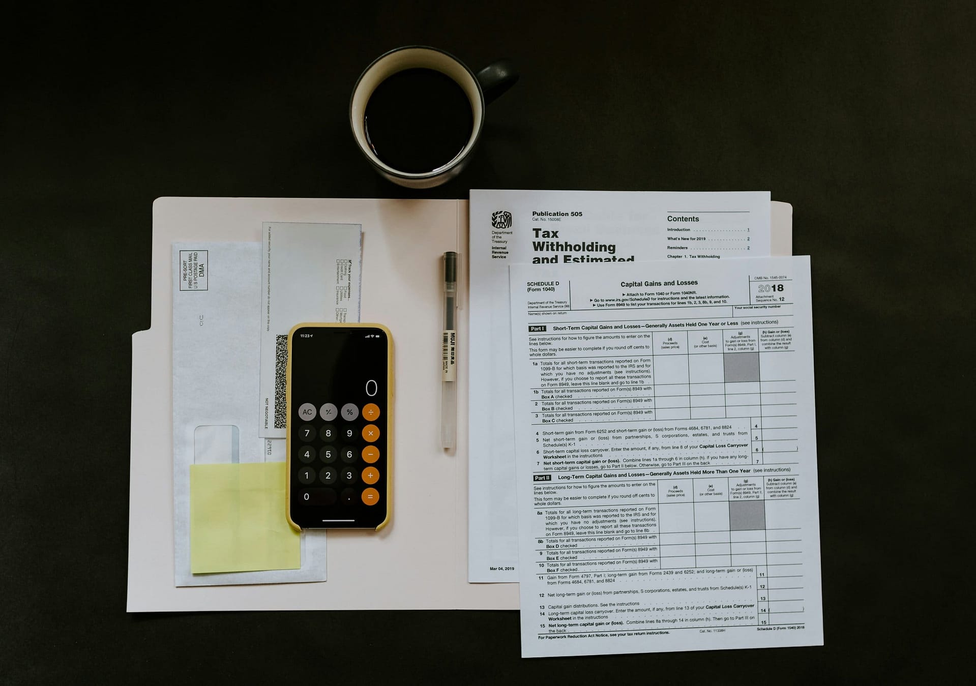 How Do Inheritance Taxes Work? 3 A tax withholding form on a desk with a calculator and a cup of coffee