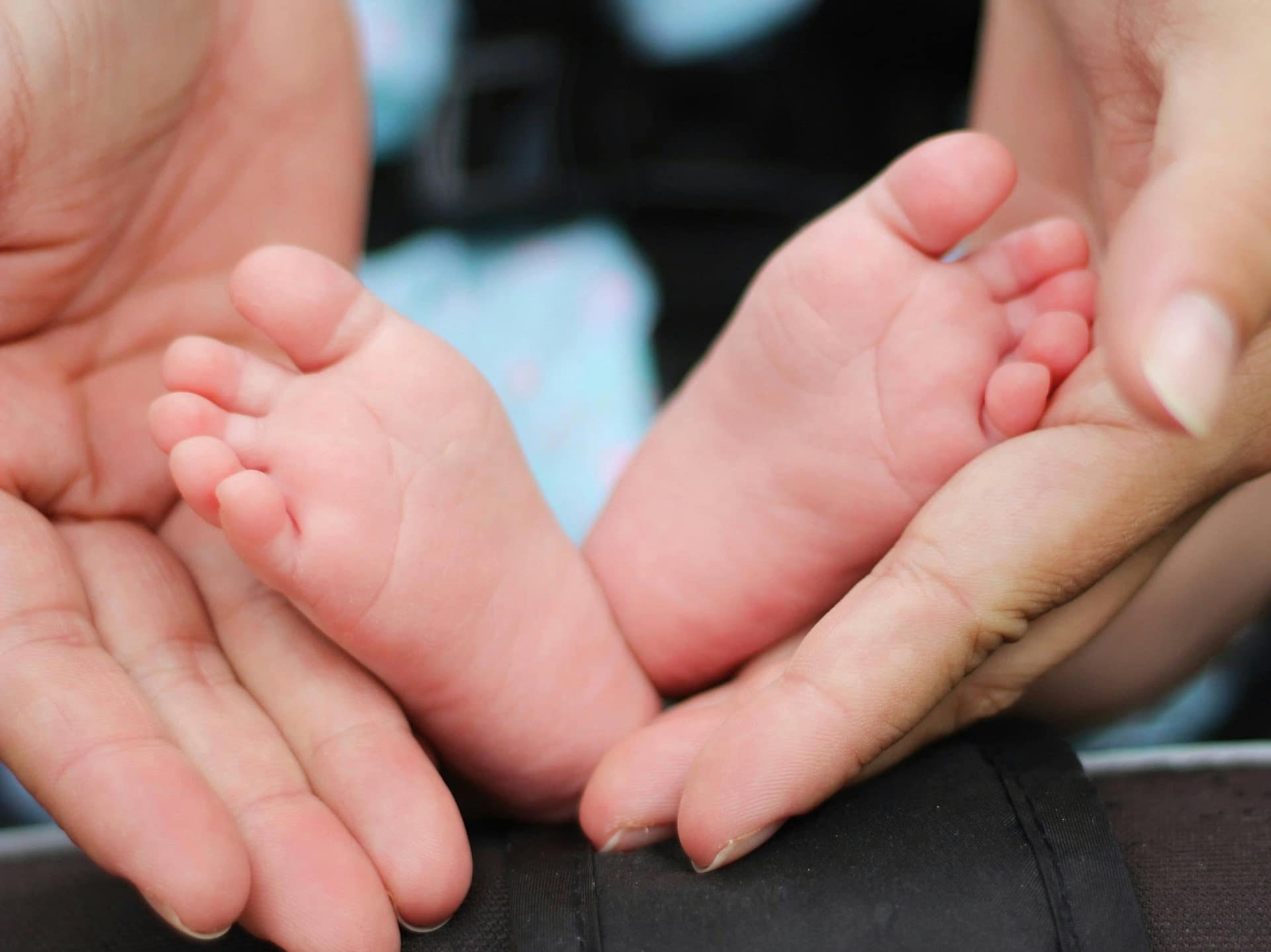 Can You Buy Life Insurance for a Dying Loved One? 3 An adult's hands cradling a baby's feet