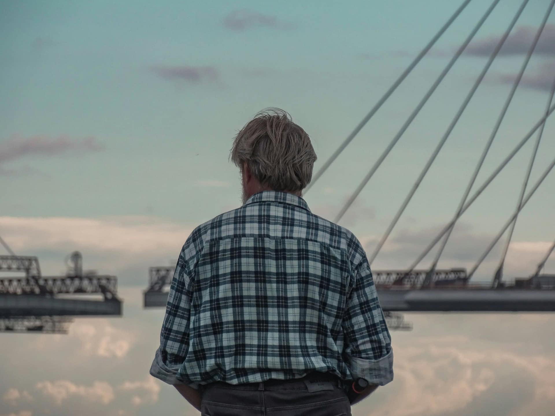 How Do Pension Death Benefits Work? 3 A man in a checked shirt looking out toward a bridge